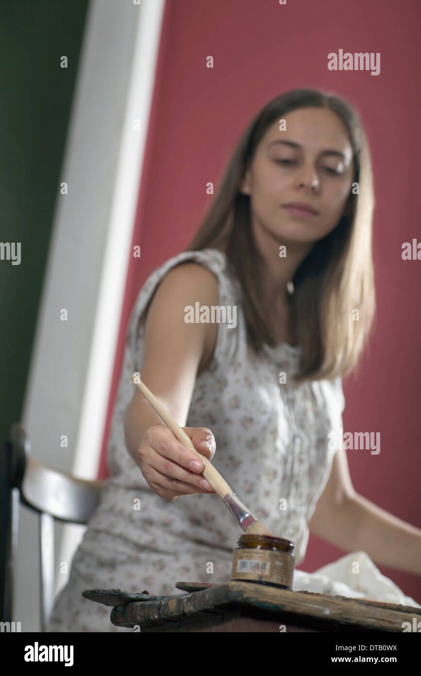 Giovane donna pittura con pennello Foto Stock