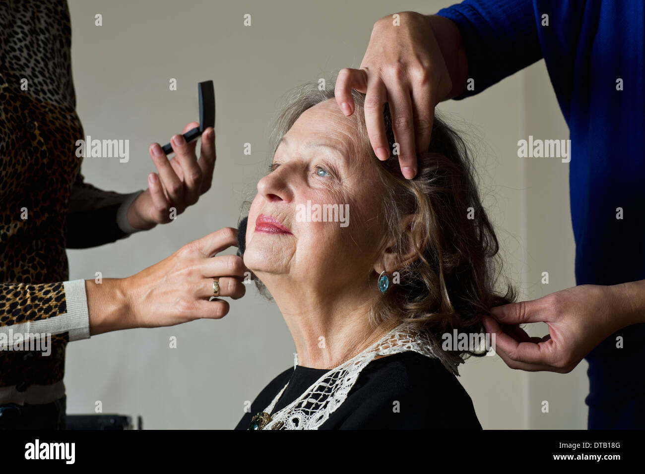 Trucco artisti applicando polvere compatta sul volto della donna Foto Stock