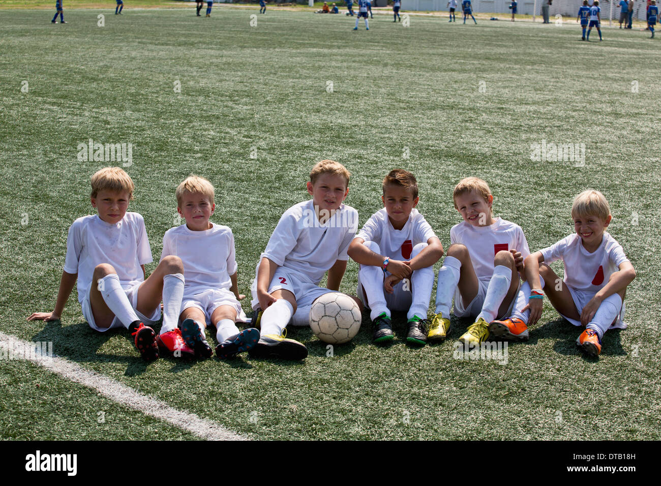 Ritratto di ragazzi seduti sul campo di calcio Foto Stock