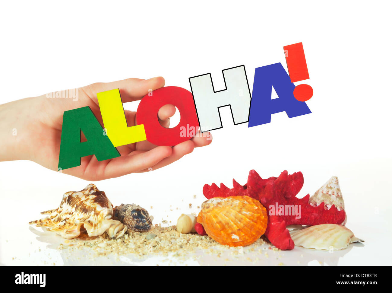 Femmina di mano azienda colorita parola Aloha contro uno sfondo bianco Foto Stock
