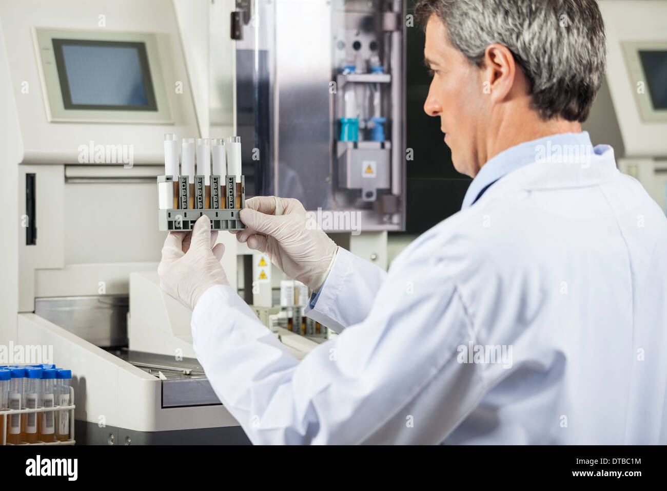 Scienziato esaminando campioni di urina in laboratorio Foto Stock