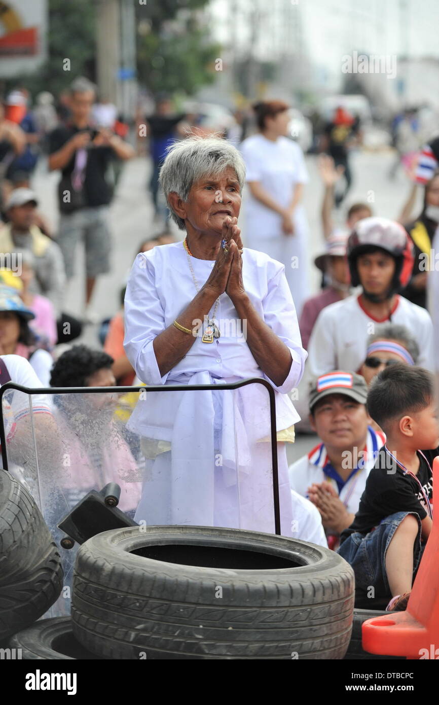 Bangkok, Tailandia. 14 feb 2014. Un governo anti-protester prega dietro pneumatici vicino al complesso del Governo sulla periferia di Bangkok, Thailandia, 14 febbraio, 2014. Polizia tailandese venerdì cancellata e fissata una strada in precedenza occupato dal governo anti-manifestanti nel cuore della capitale. Credito: Gao Jianjun/Xinhua/Alamy Live News Foto Stock