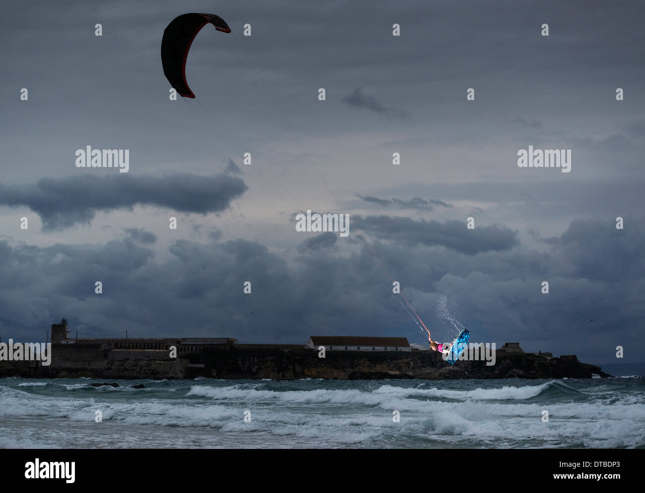 Azione di Kitesurf a Tarifa, Cadice, Andalusia, con "La Isla' in background. Foto Stock