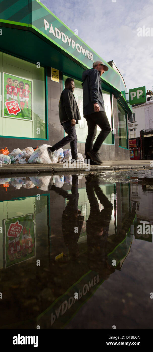 La gente a piedi passato un ramo di Paddy Power bookmakers in Hackney, Londra, 8 gennaio 2014. Foto Stock