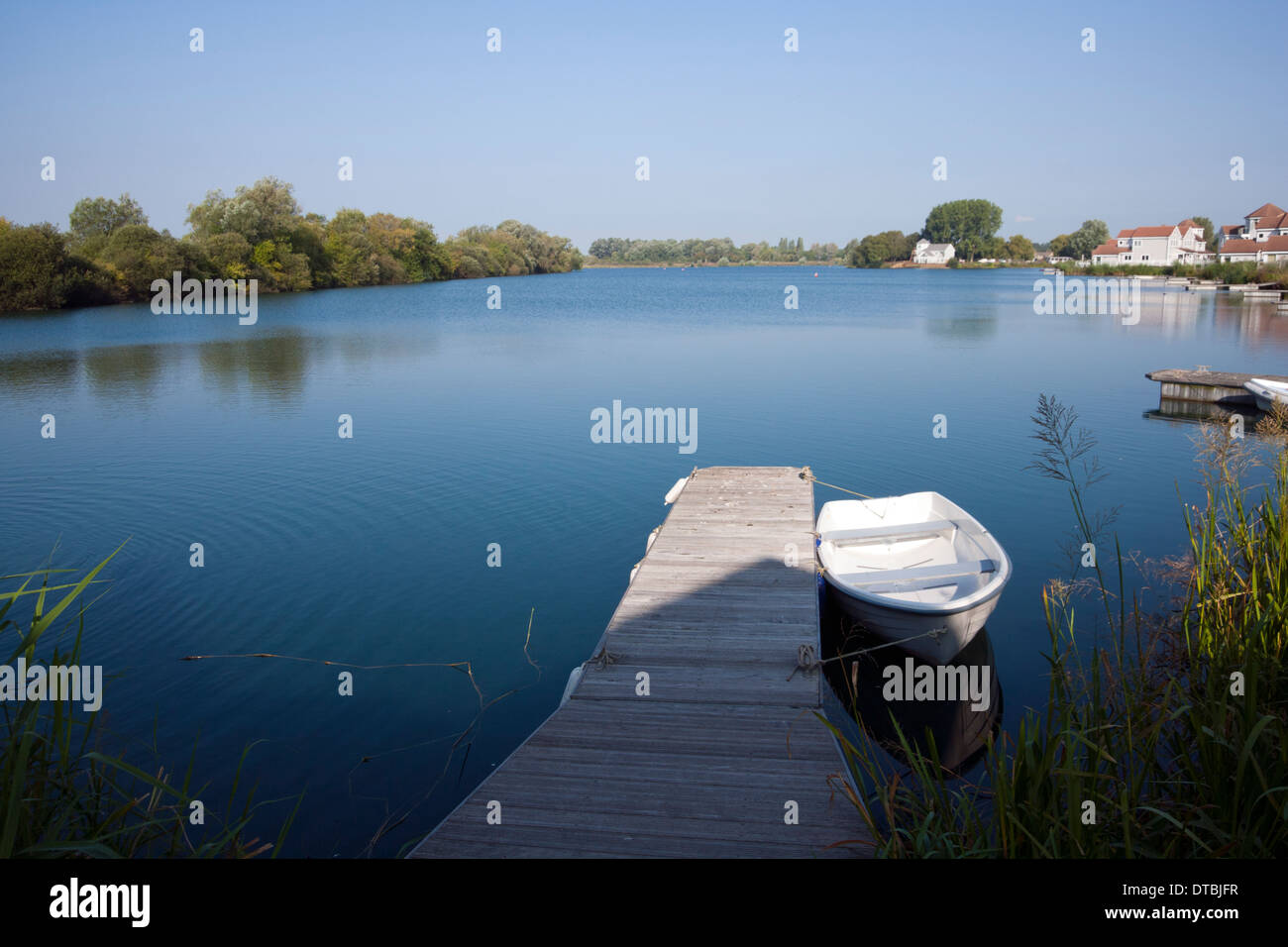 Una piccola barca ormeggiata su un lago a Cotswold Water Park casa vacanze complesso, Gloucestershire, England, Regno Unito Foto Stock