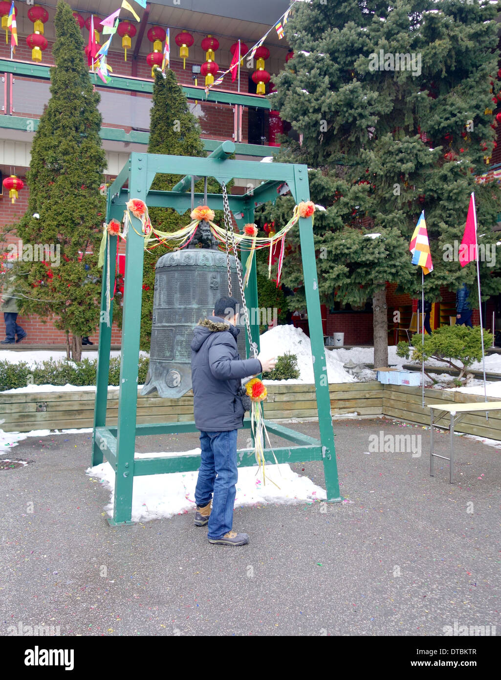 L'uomo suonando una campana in un Cinese Tempio Buddista fuori Toronto, Canada Foto Stock