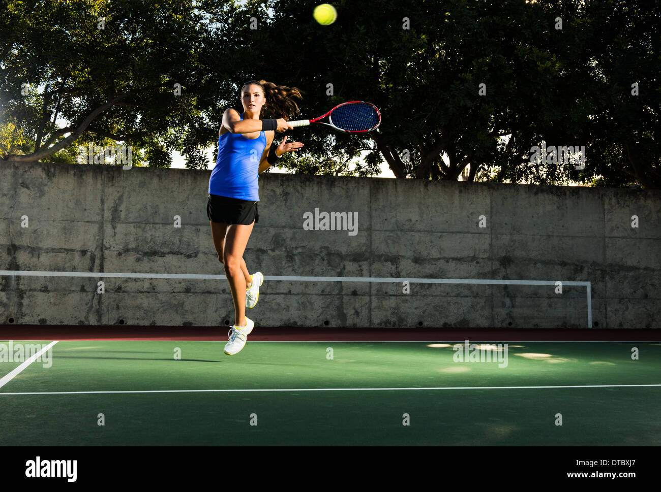 Femmina giocatore di tennis di colpire la sfera Foto Stock