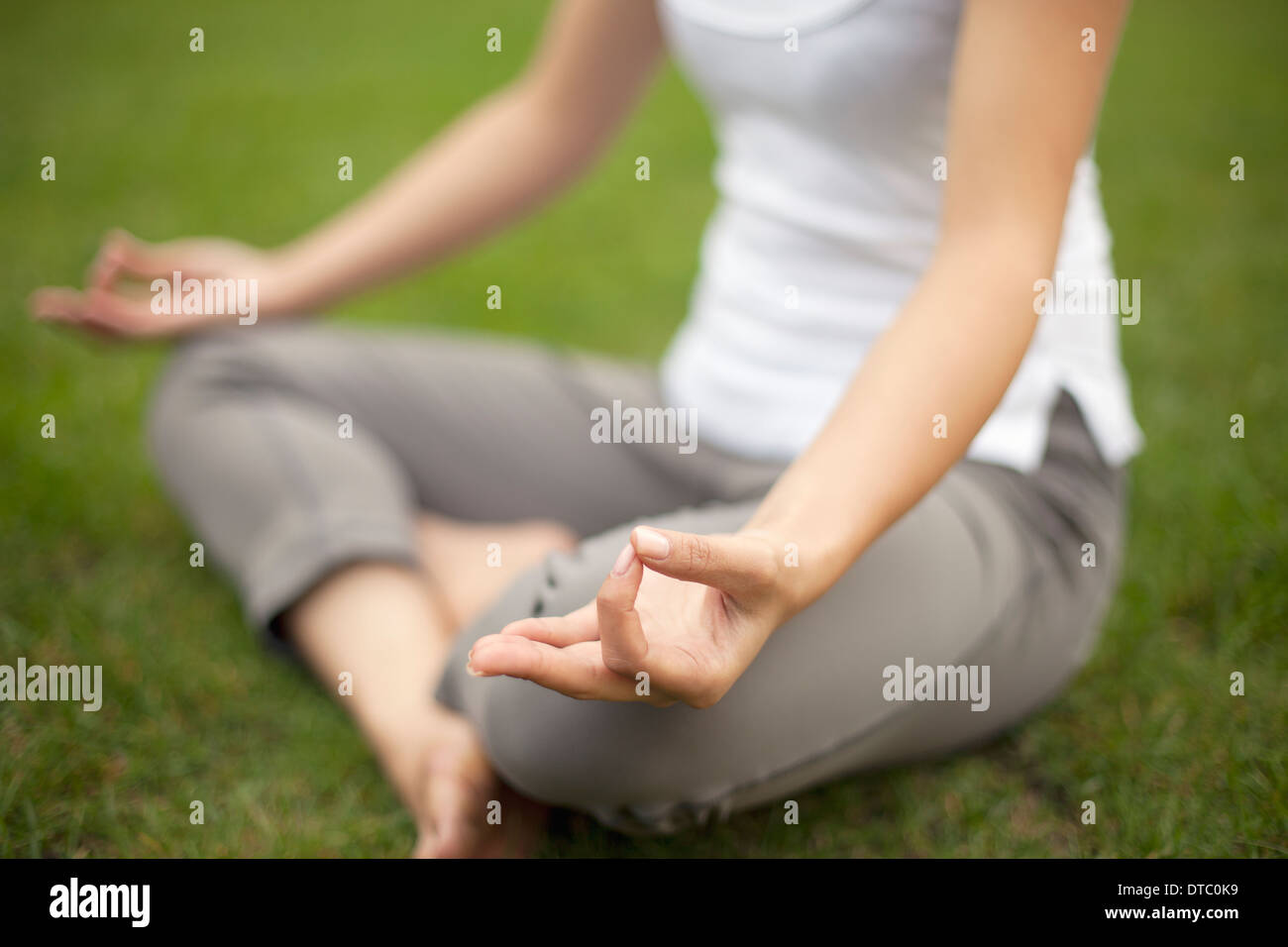 Immagine ritagliata della giovane donna nel parco la pratica posizione del loto Foto Stock