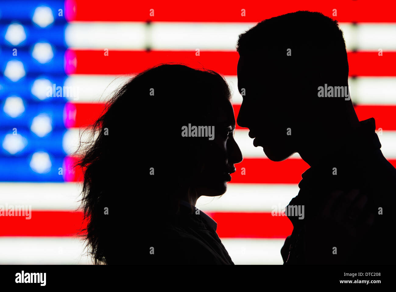 Silhouette di coppia giovane nella parte anteriore della bandiera americana Foto Stock
