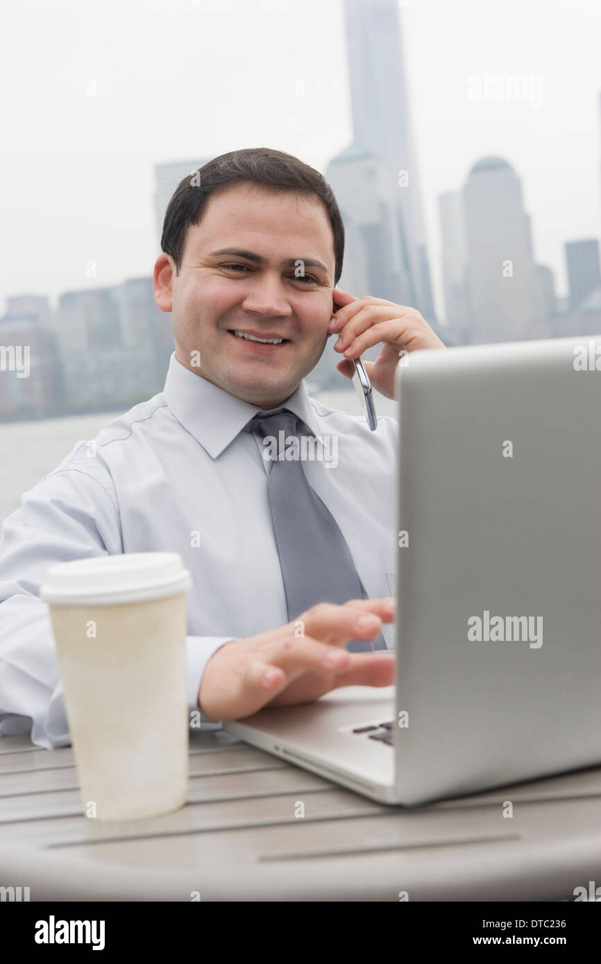 Uomo d affari con computer portatile all'aperto, Jersey City, New Jersey, STATI UNITI D'AMERICA Foto Stock