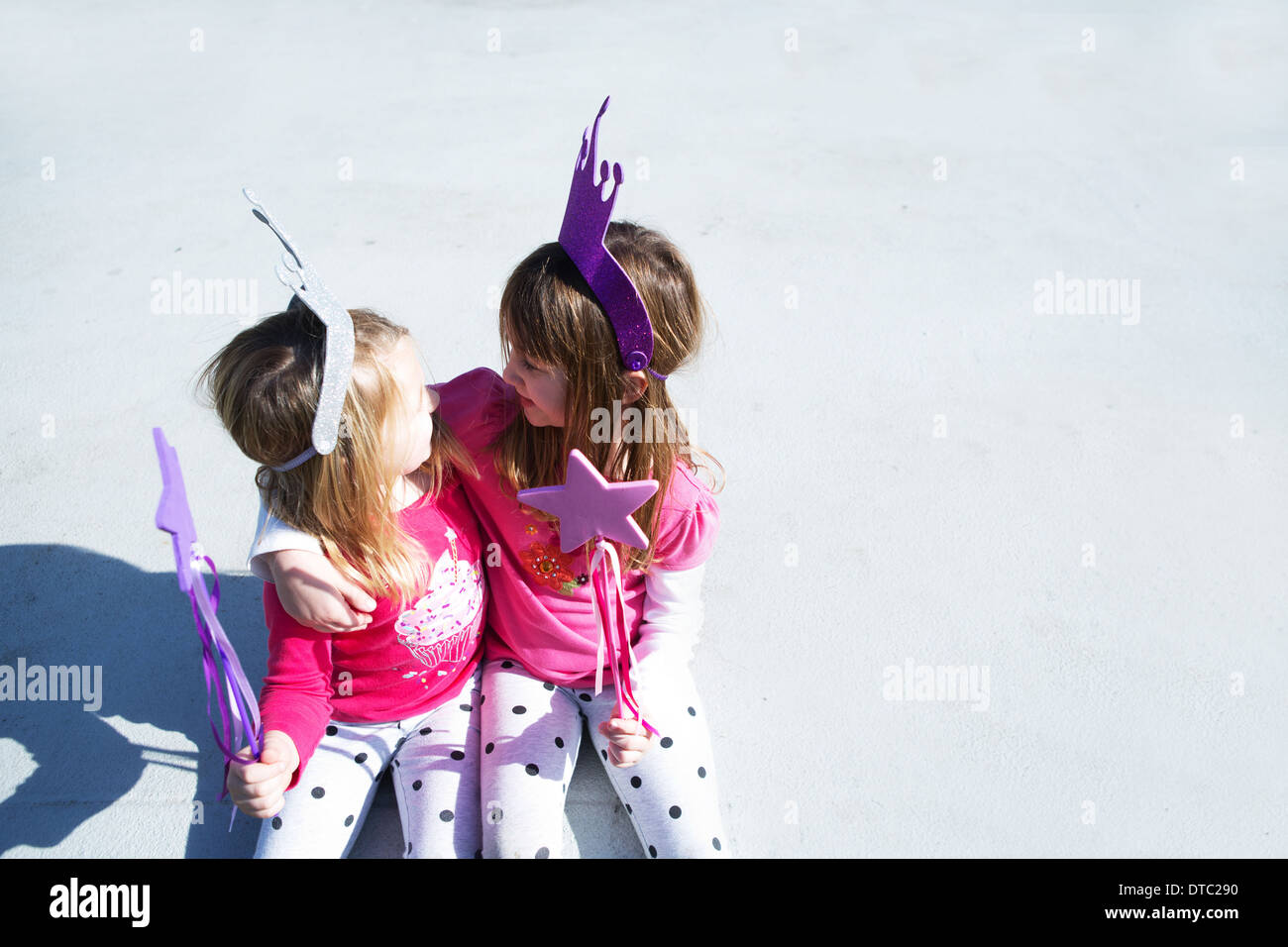 Due giovani sorelle vestite come le fate azienda wands Foto Stock