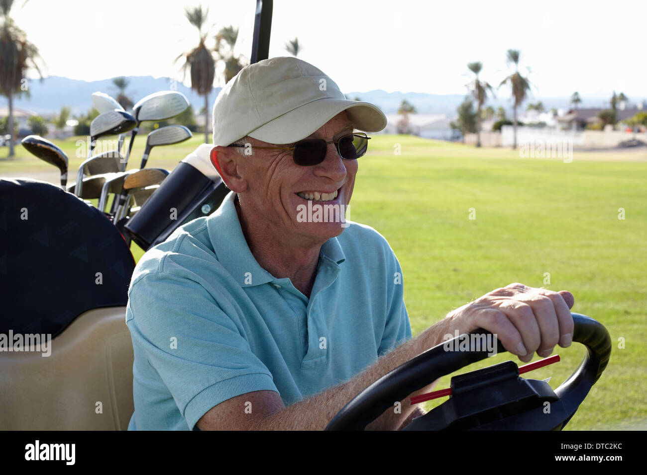 Senior golfer maschio guida golf buggy Foto Stock