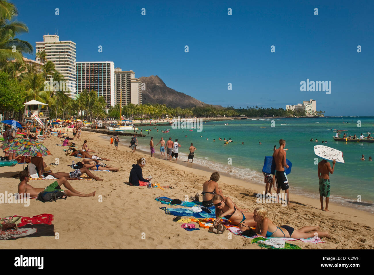 La gente sulla sabbia presso la spiaggia di Waikiki, Honolulu Oahu, Hawaii Foto Stock