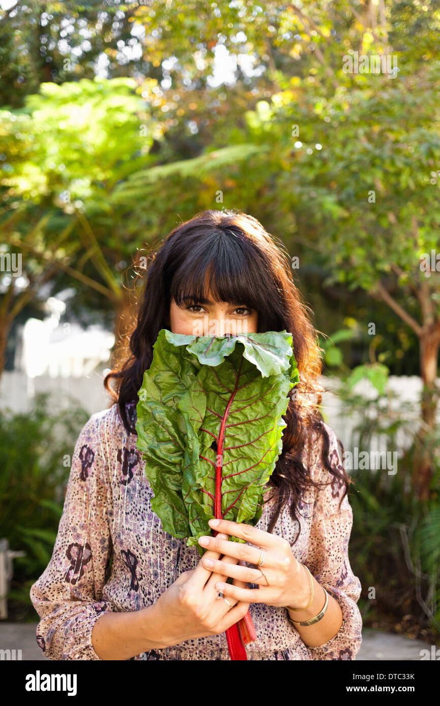 Ritratto di giovane donna azienda foglia vegetale Foto Stock