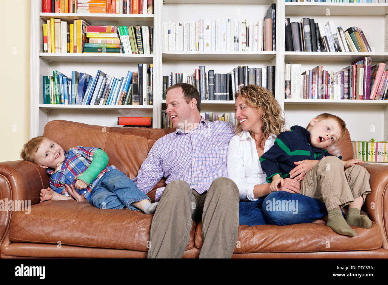 Metà dei genitori adulti e giovani figli divertirsi sul divano Foto Stock