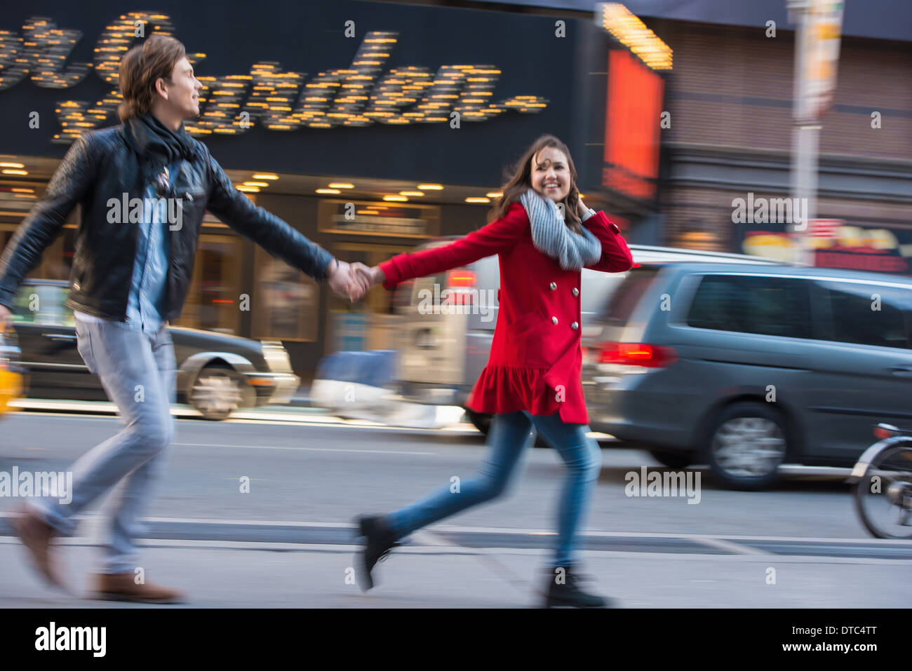 Coppia giovane che corre lungo Street, New York City, Stati Uniti d'America Foto Stock