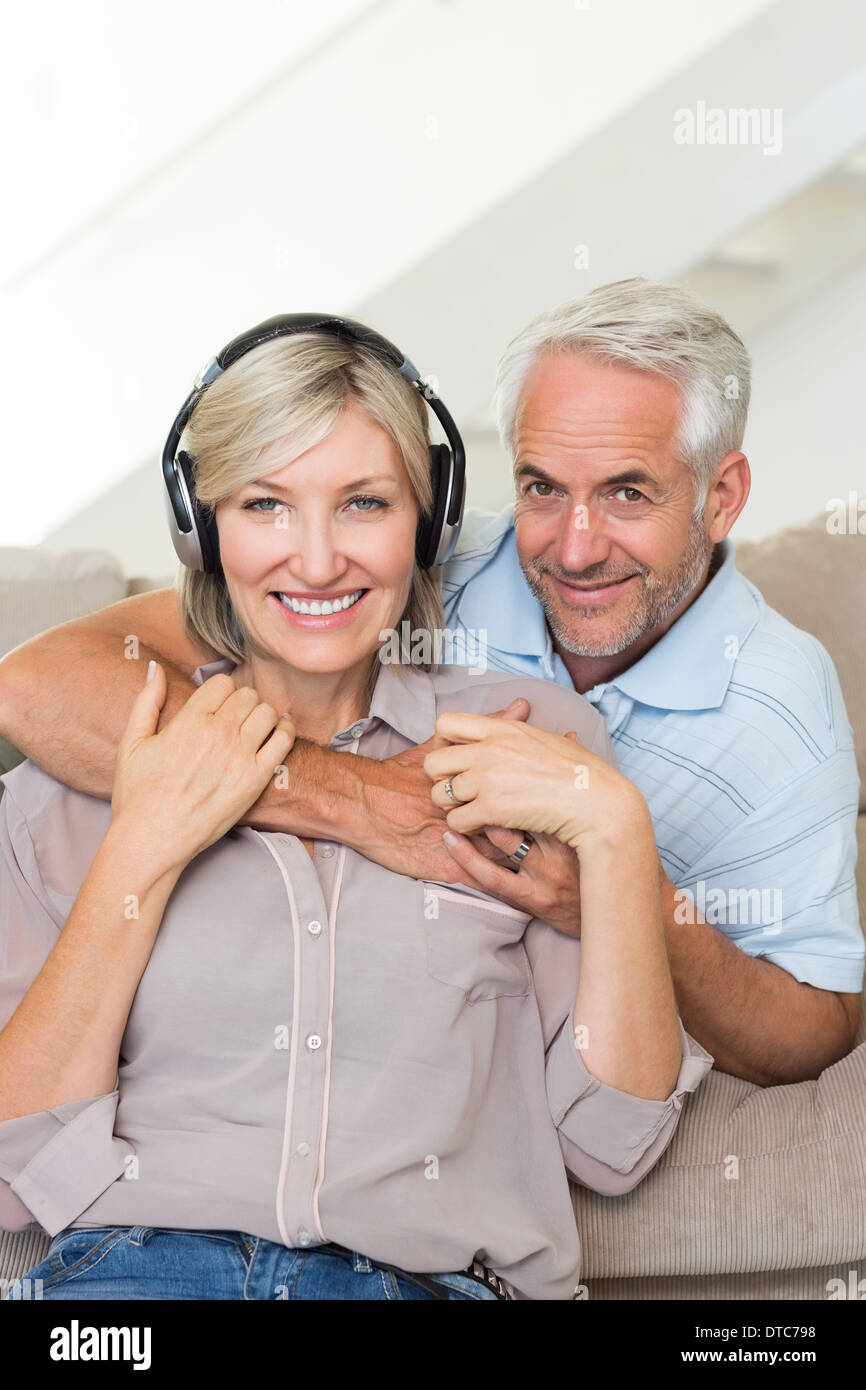 Uomo maturo abbracciando la donna da dietro sul divano Foto Stock