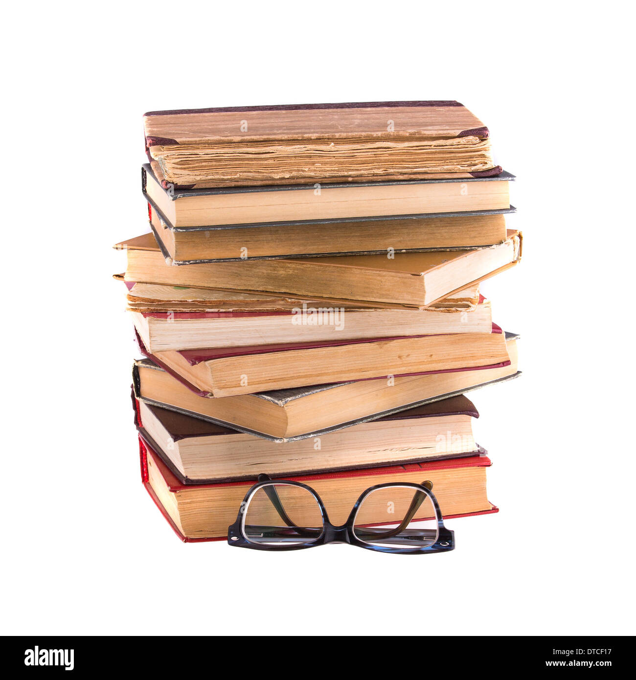 Pila di vecchi libri antichi e gli occhiali spessi, bordati di isolati su sfondo bianco. Foto Stock