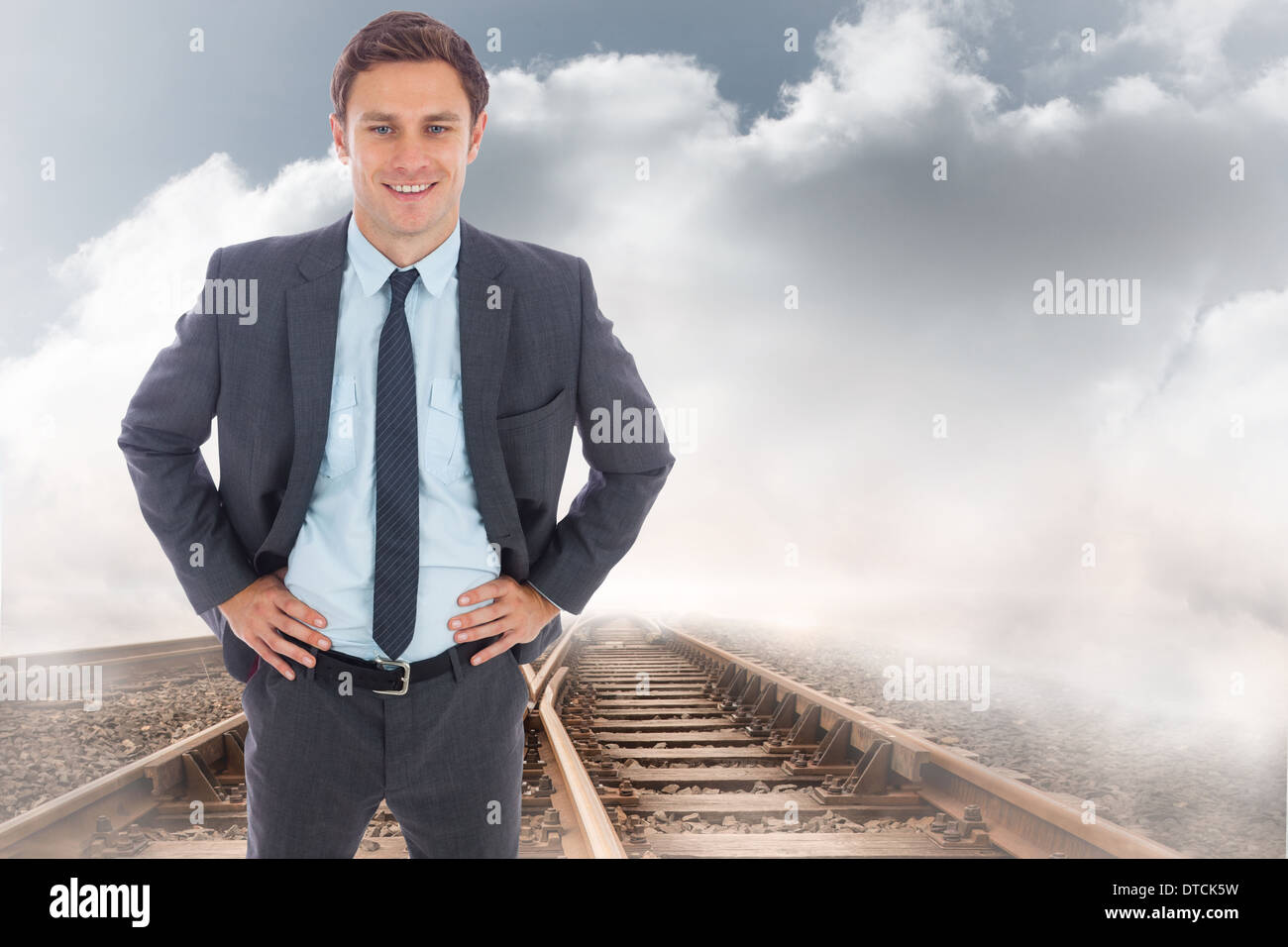 Immagine composita di allegro imprenditore in piedi con le mani sui fianchi Foto Stock