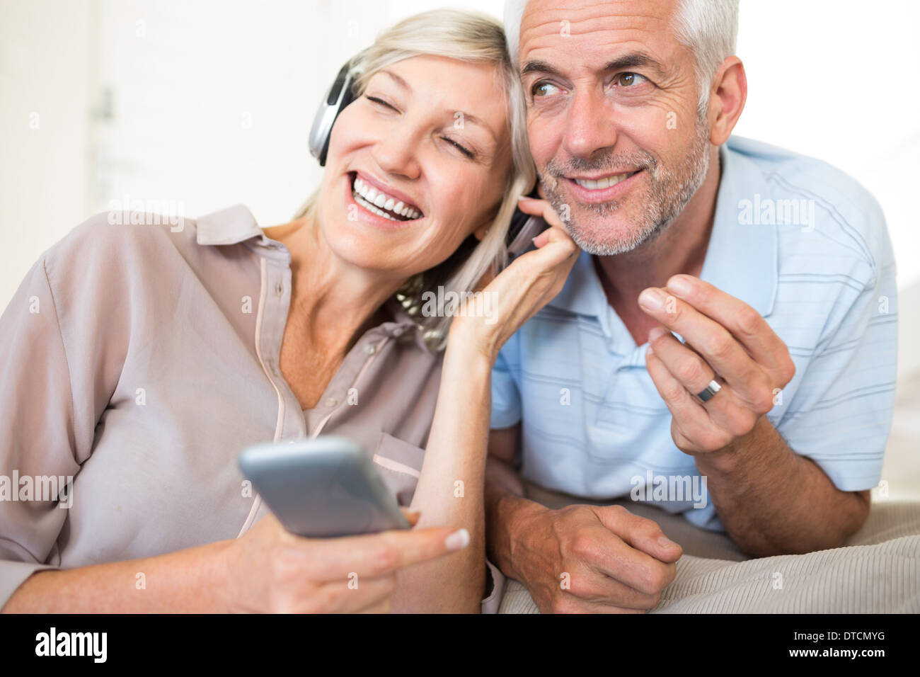 Coppia matura con le cuffie e il telefono cellulare Foto Stock