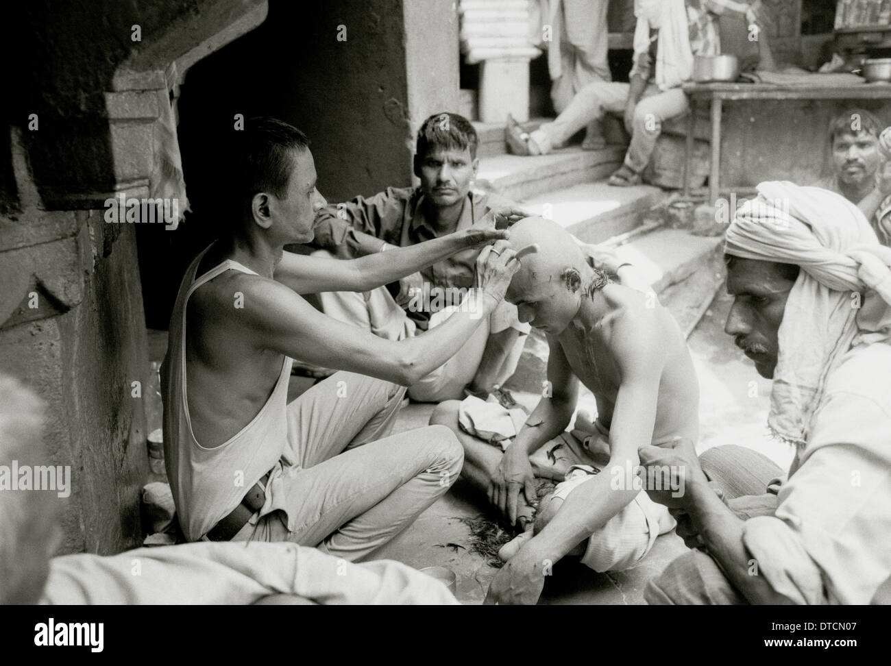 Funerale rituale taglio di capelli alla cremazione Manikarnika ghat Varanasi Benares in Uttar Pradesh in India in Asia del Sud. Reportage morte Fiume Gange Travel Foto Stock