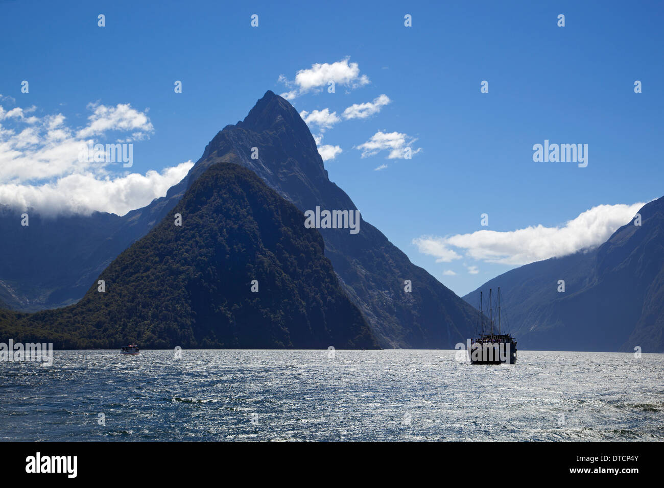 Imbarcazione turistica in Milford Sound accanto a Mitre peak, Fiordland, Isola del Sud, Nuova Zelanda Foto Stock