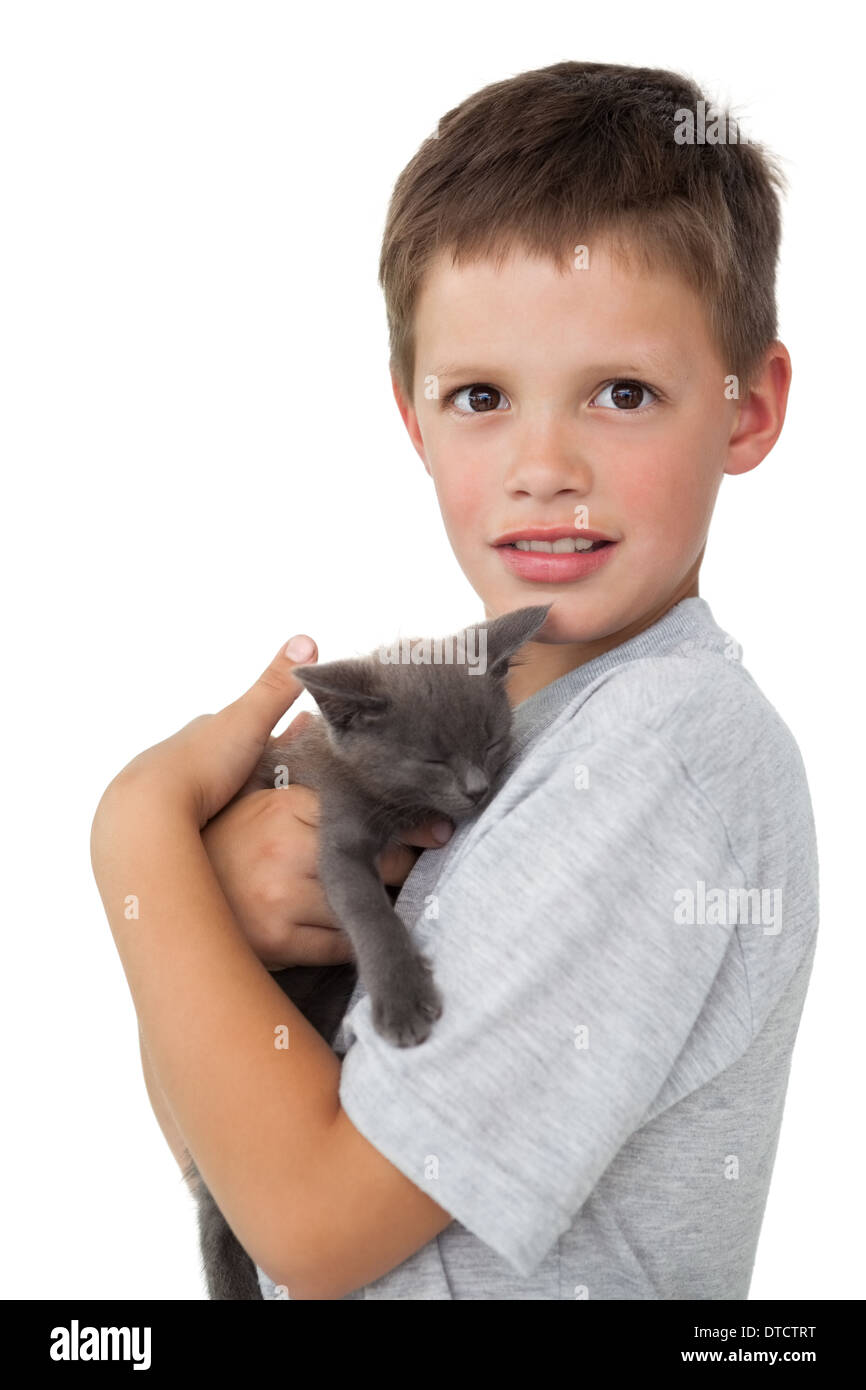 Little Boy holding grigio gattino sorridente in telecamera Foto Stock