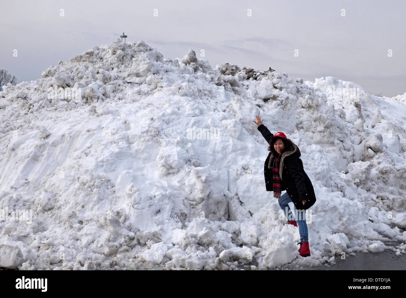 Donna asiatica scalata di un enorme cumulo di neve durante l'inverno del 2013/2014 in New Jersey, STATI UNITI D'AMERICA Foto Stock