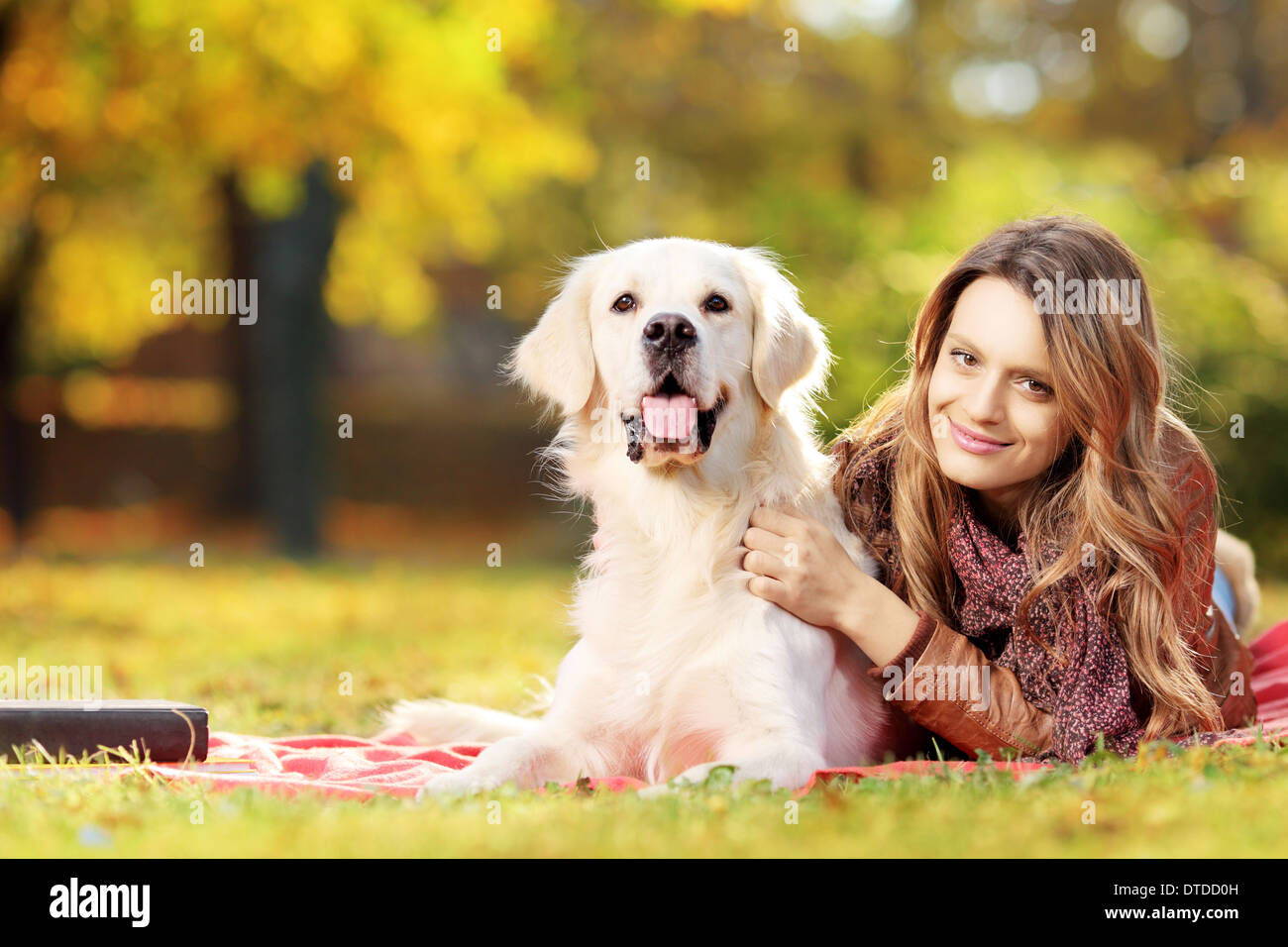 Giovani femmine sdraiato con il suo labrador retriever cane in un parco Foto Stock