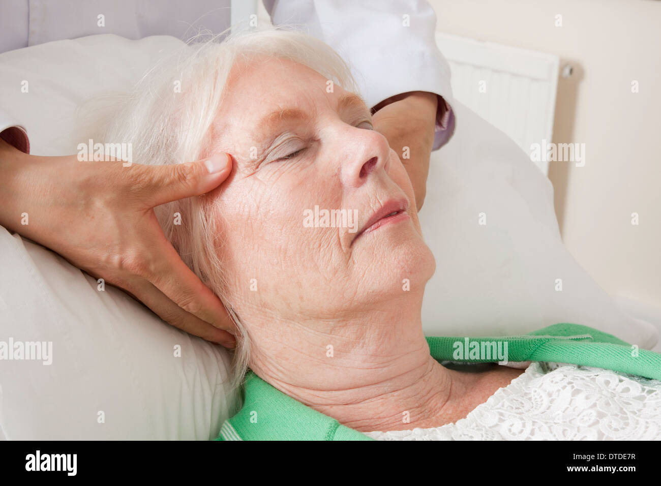 Donna matura la ricezione di digitopressione come parte del trattamento acutherapy Foto Stock