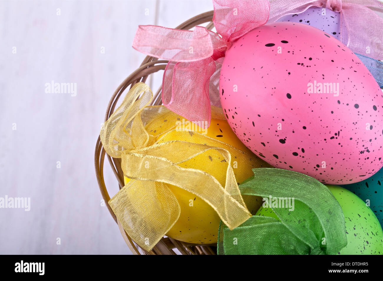 Uova di Pasqua in un cesto su uno sfondo luminoso Foto Stock