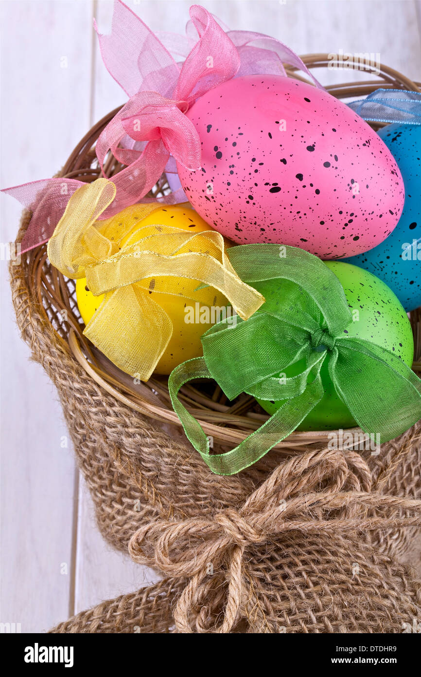 Uova di Pasqua in un cesto su uno sfondo luminoso Foto Stock