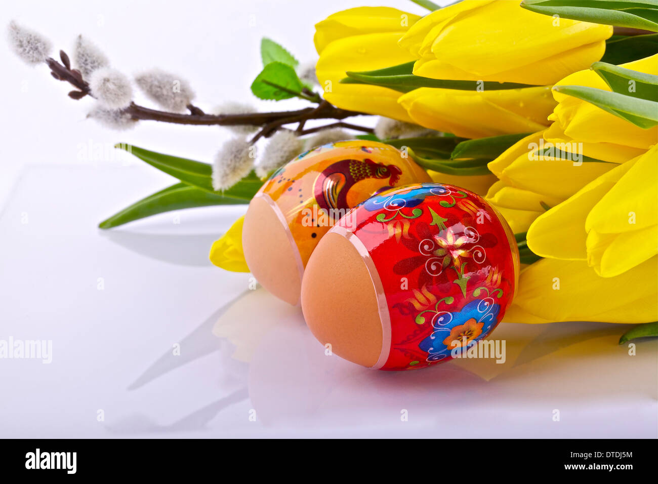 Uova di Pasqua e tulipani gialli su sfondo chiaro Foto Stock