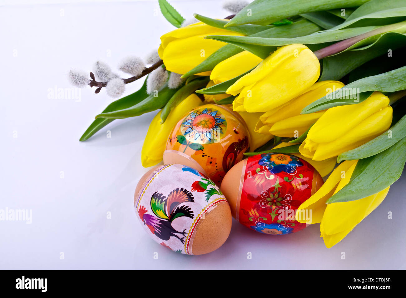 Uova di Pasqua e tulipani gialli su sfondo chiaro Foto Stock