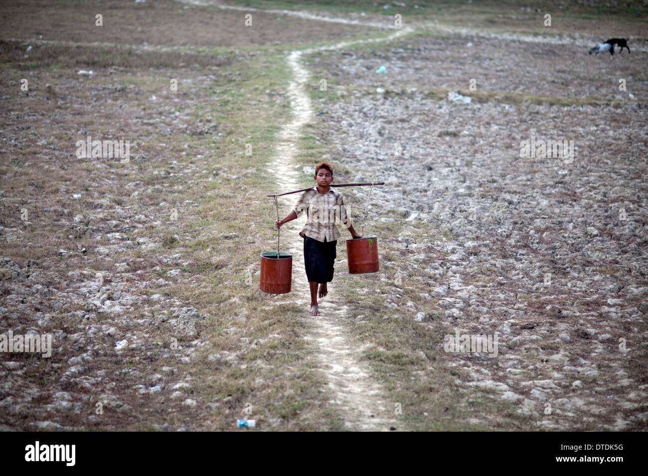 Una donna il riempimento di contenitori con acqua in un piccolo lago nel Dala Township, Myanmar, lunedì, 6 maggio 2013 Foto Stock