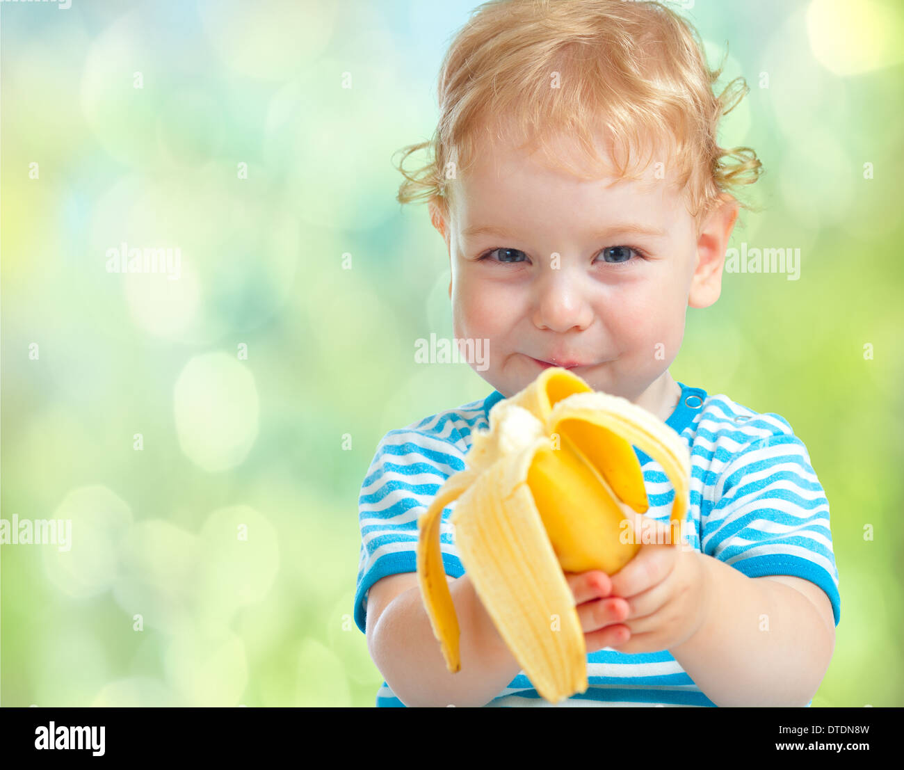 Capretto felice di mangiare frutta banana. cibo sano concetto di mangiare. Foto Stock