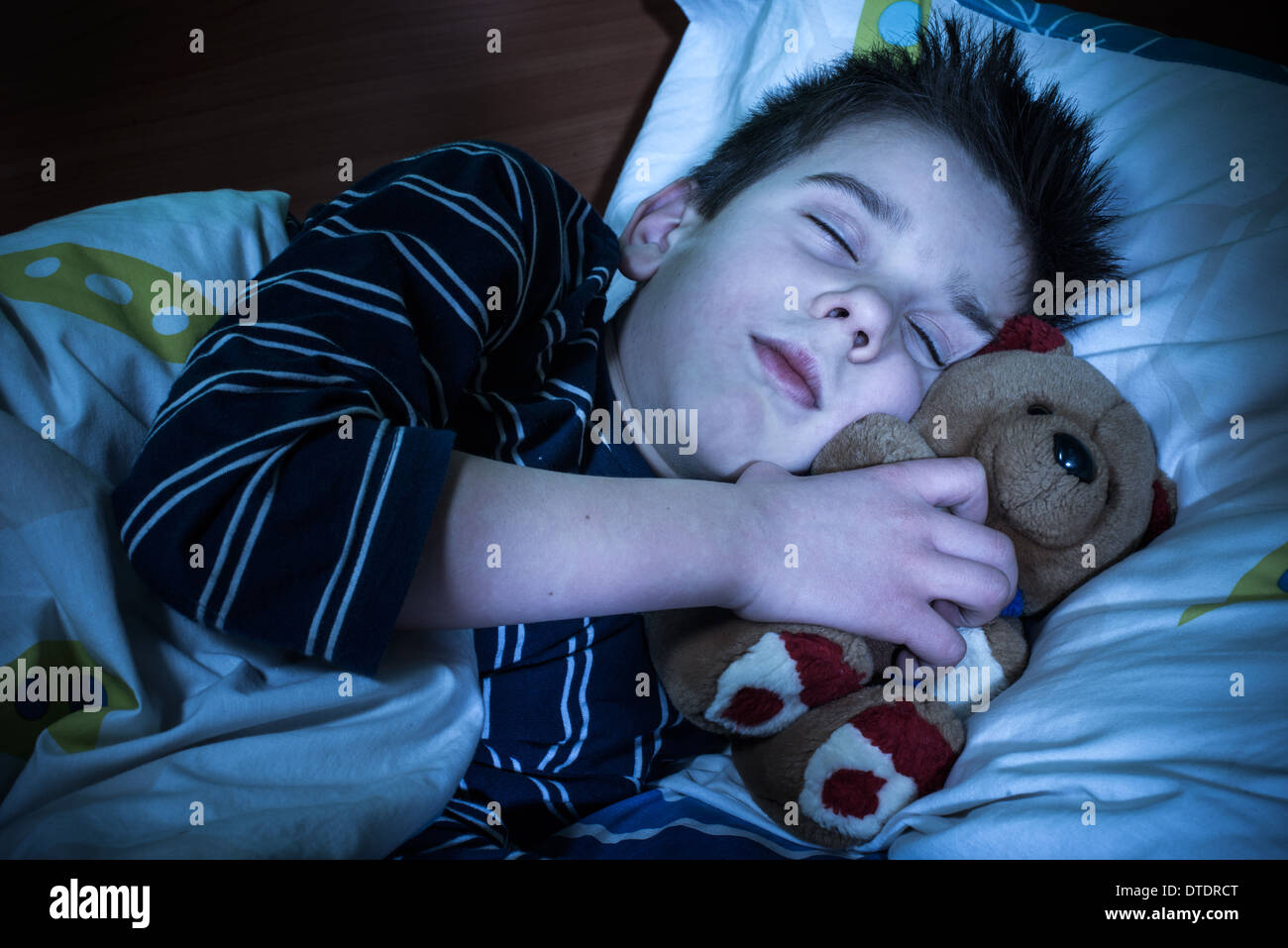 Bambino addormentato con il suo giocattolo orso. Foto Stock