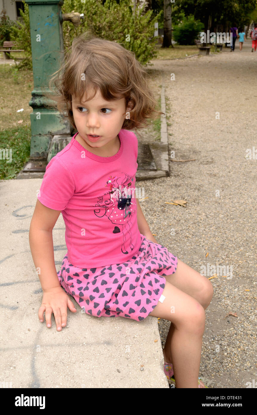 4 anno vecchia ragazza in abito rosa al parco giochi Foto Stock