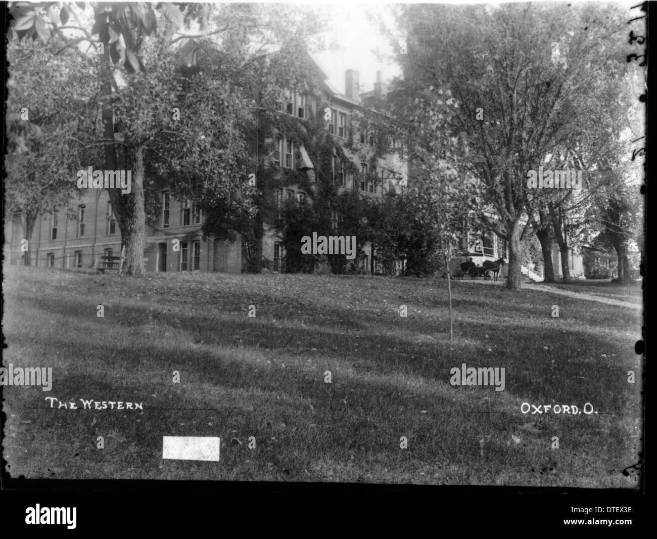 Una vista parzialmente oscurata di Peabody Hall, un edificio storico dell'Università di Miami, scattata in una fotografia probabilmente dell'inizio del XX secolo. L'immagine mostra un assaggio delle caratteristiche architettoniche della sala, anche se alcune parti sono nascoste. Foto Stock