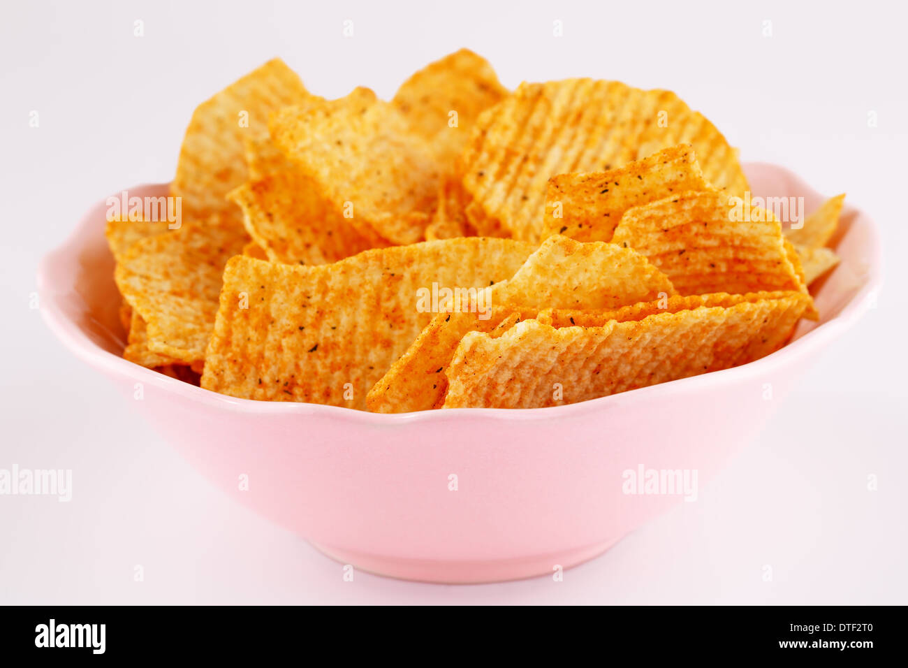 Potato Chips in rosa ciotola isolato su sfondo grigio. Foto Stock