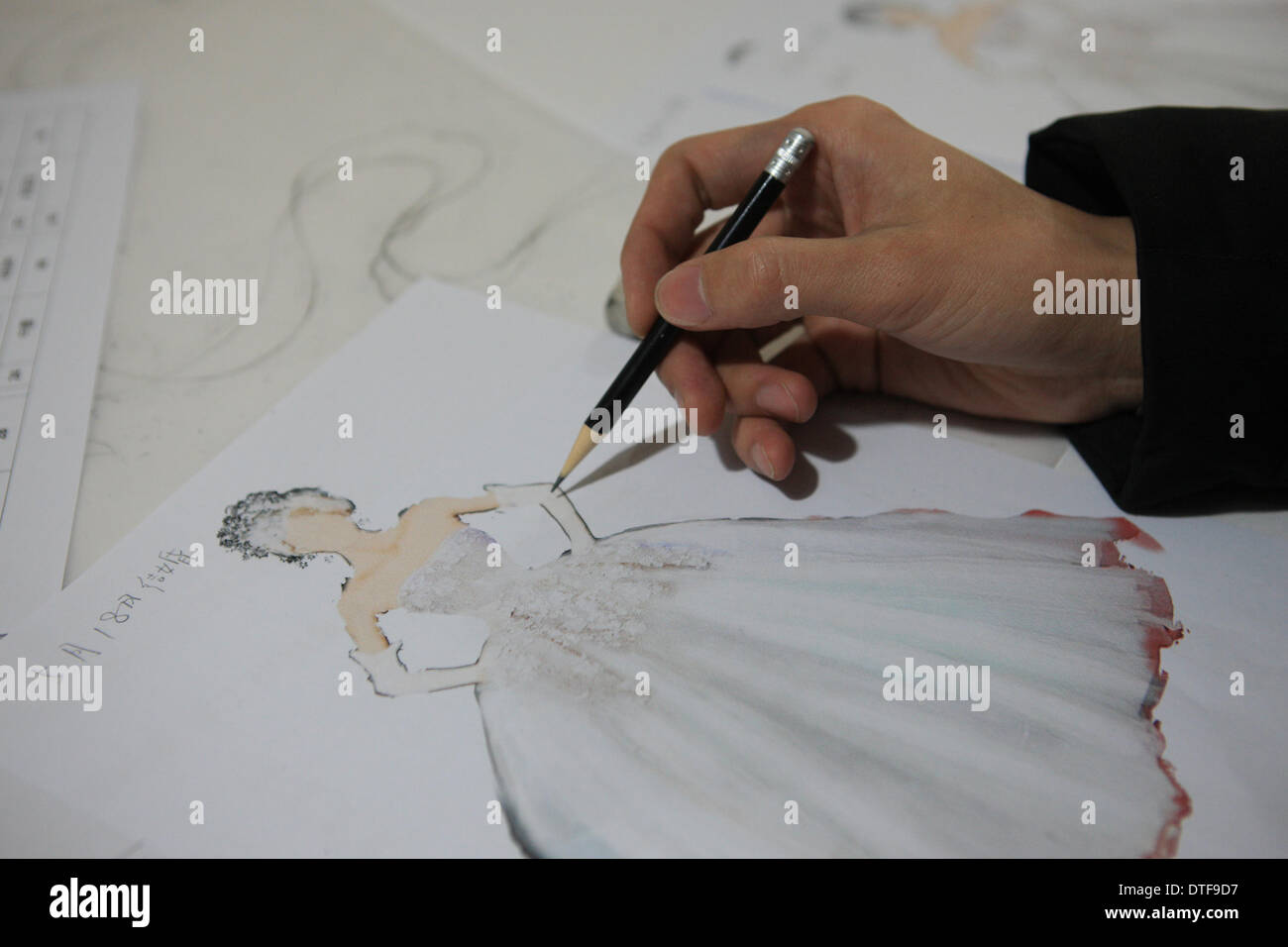 Pechino, Cina. 17 feb 2014. Un pittore fa un disegno per designer Laurence Xu a Pechino Capitale della Cina, Feb 17, 2014. Xu, un, Shandong Cina-NATO, Parigi-basato designer, che mostrerà le sue nuove creazioni alla settimana della moda di Parigi nel mese di luglio. Credito: Liu Changlong/Xinhua/Alamy Live News Foto Stock