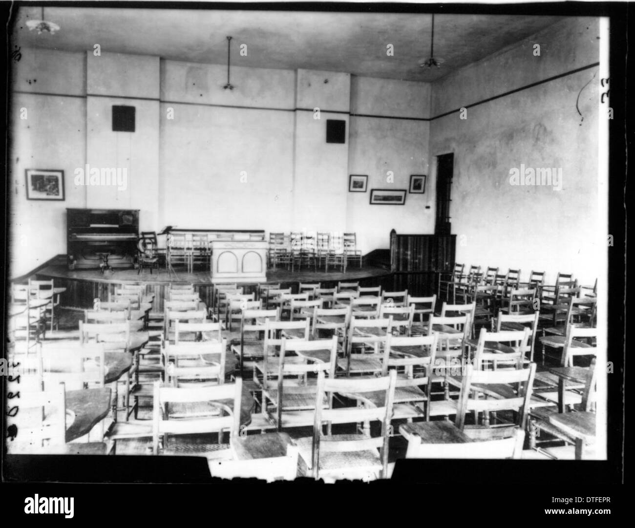 L'interno di un auditorium universitario presenta una disposizione con scrivanie, strumenti musicali e un palcoscenico, che riflette l'ambiente educativo e gli aspetti culturali di uno spazio accademico storico. Foto Stock