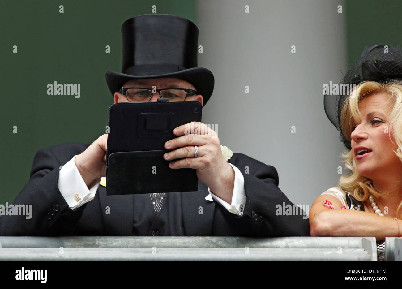 Ascot Regno Unito elegantemente vestito uomo con un cilindro digitato qualcosa sul suo Tablet PC Foto stock Alamy