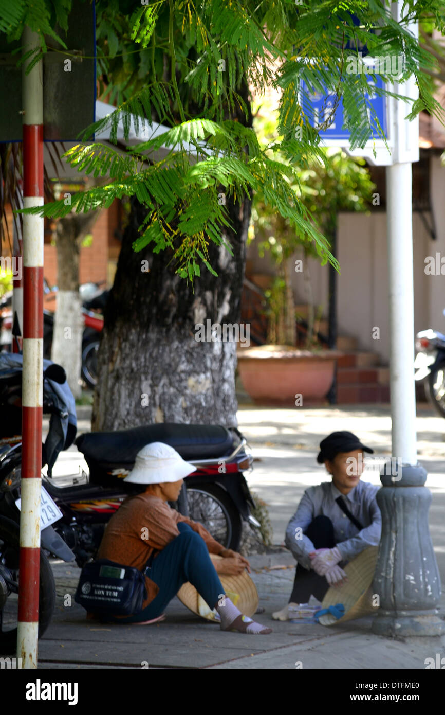 Il vietnamita le donne sedute a angolo di strada in chat Foto Stock