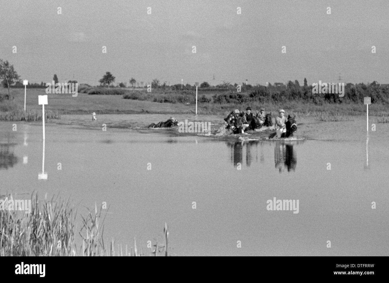 Amburgo, Germania, cavalli e fantini di attraversare il lago sul Racecourse Foto Stock