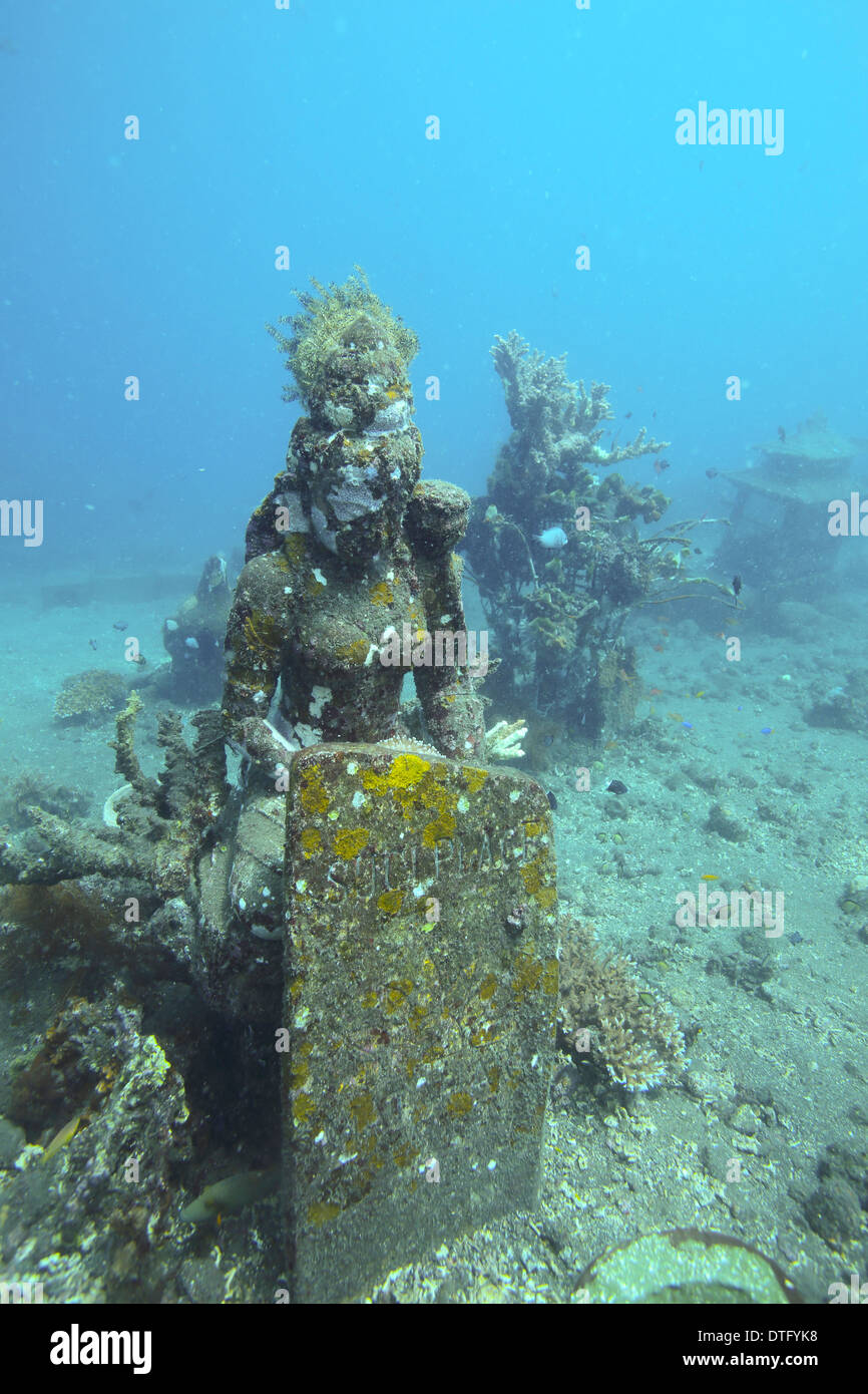 Divinità indù statua di pietra sul oceano pavimento in Amed, east Bali Foto Stock