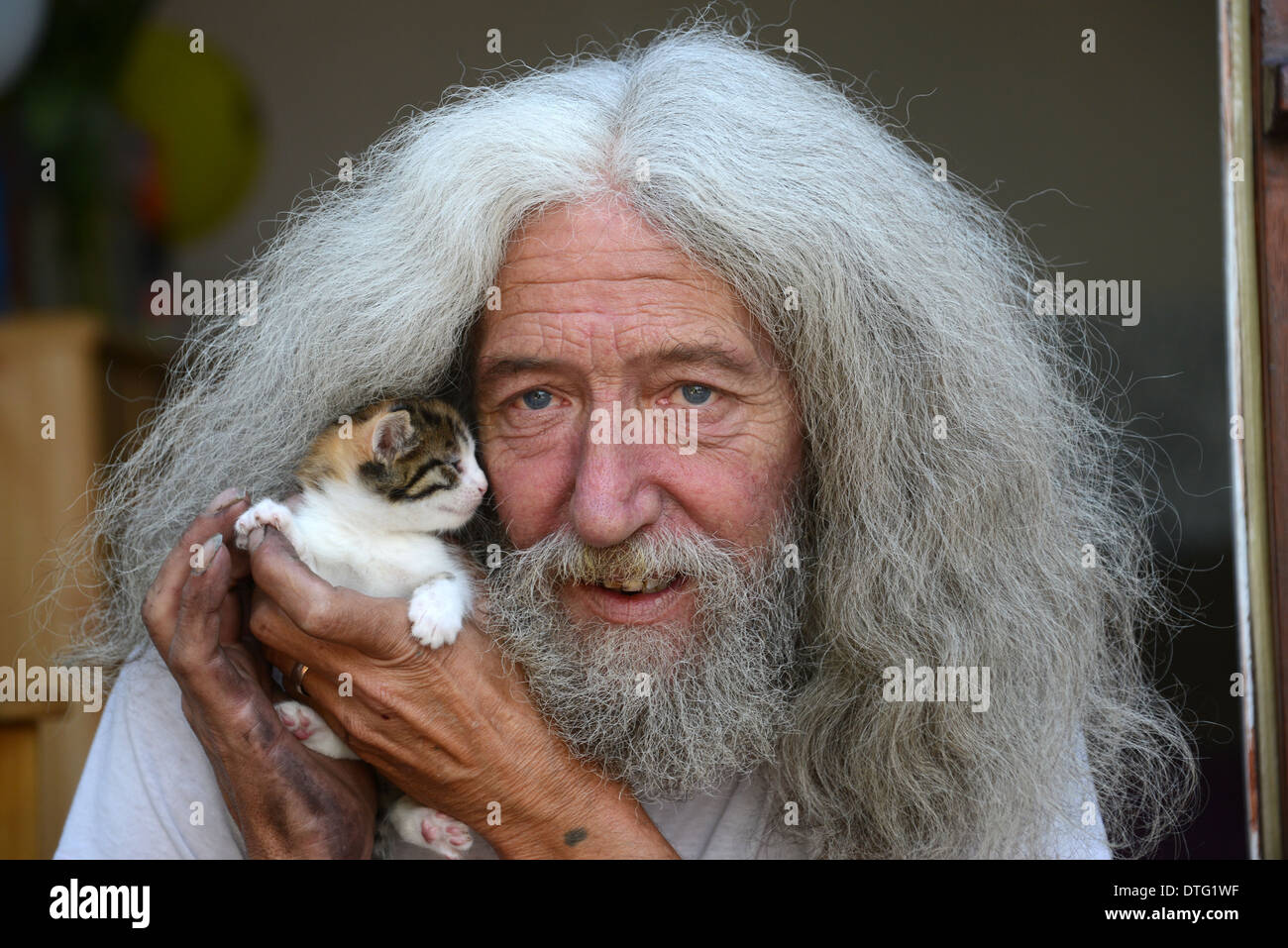 Uomo con capelli lunghi e barba John Julian con uno dei gattini che ha trovato nella sua capanna. Gli amanti degli animali kitten salvataggio salvato Gran Bretagna gente del Regno Unito maschio Foto Stock