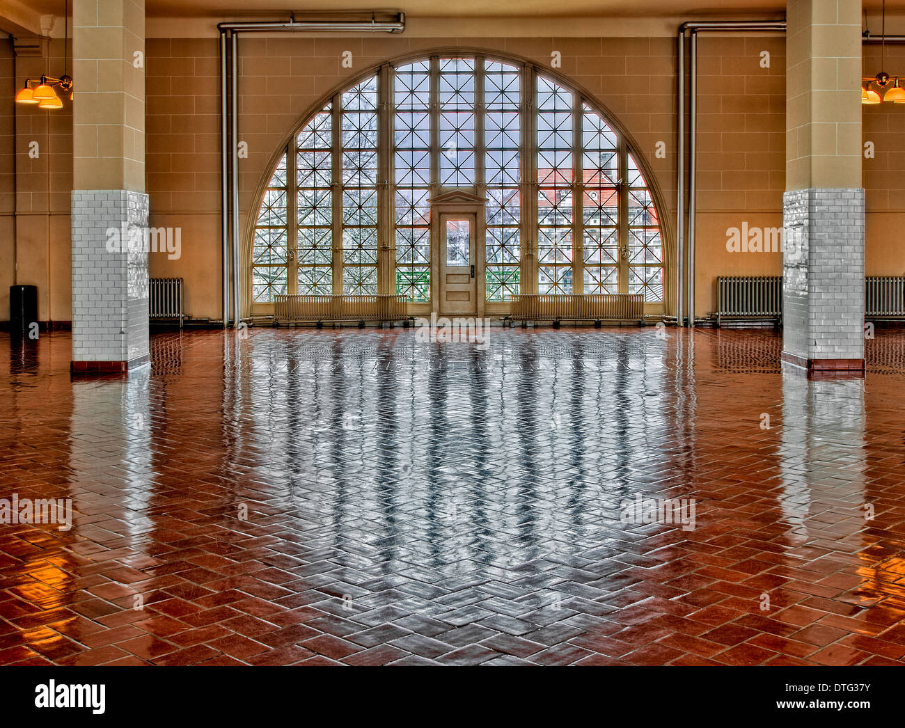 Una delle finestre circolari si riflette sulle piastrelle restaurato nel Registro di sistema Hall di Ellis Island Liberty State Park. Foto Stock