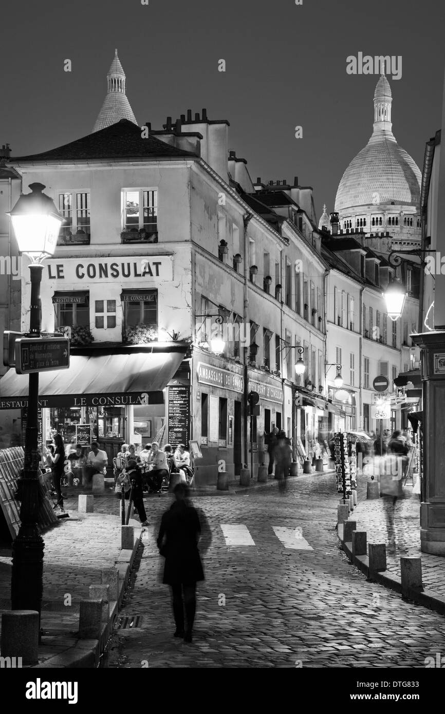 Crepuscolo in strade lastricate di Montmartre con torre del Basilique du Sacre Coeur oltre, Parigi Francia Foto Stock