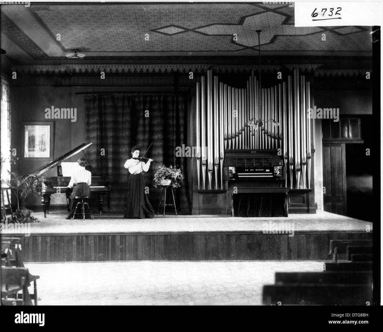 Questa immagine storica del 1905 raffigura donne che si esibiscono al pianoforte e al violino al Western College, riflettendo l'importanza dell'educazione femminile e della musica nell'America dei primi anni del XX secolo. La fotografia evidenzia il significato culturale della performance musicale e della vita accademica del tempo. Foto Stock